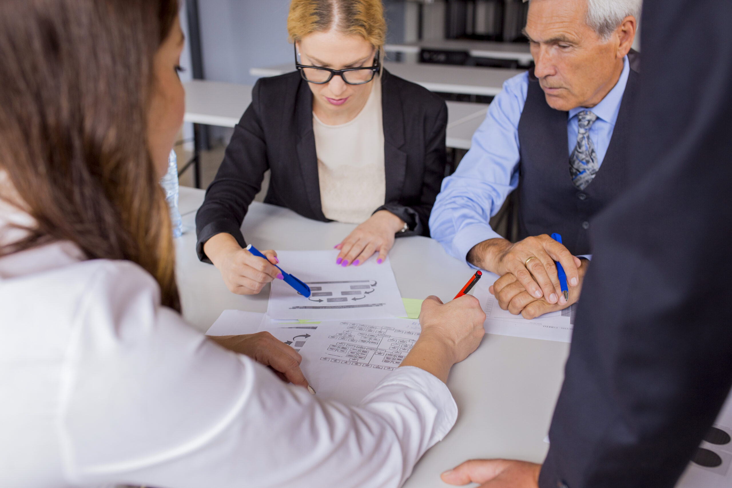 Insurance consultant and clients reviewing PPLI strategy documents, highlighting the collaborative approach between financial professionals and high-net-worth individuals during Private Placement Life Insurance implementation planning.