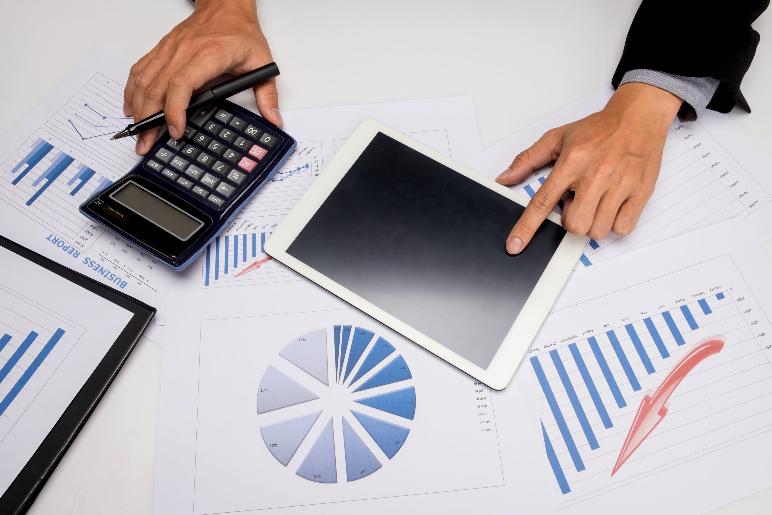 Professional financial planning workspace with calculator, tablet, and business reports showing charts and graphs for PPLI installment sales tax strategy analysis