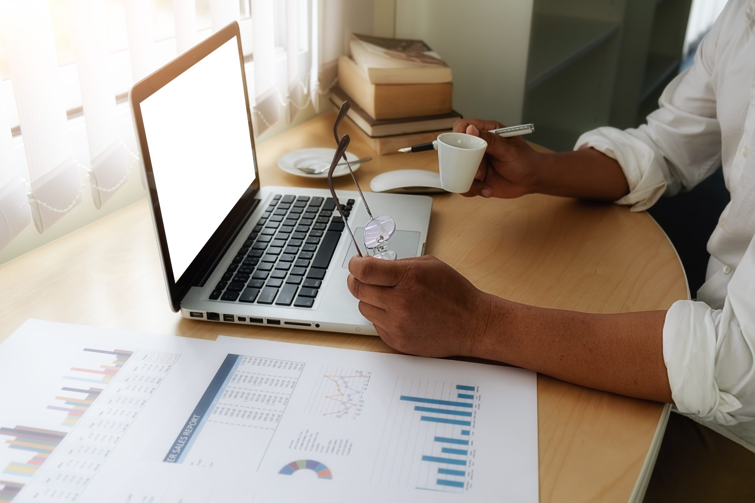 Professional financial advisor analyzing PPLI policy documents and charts on laptop while reviewing private placement life insurance surrender and loan strategy options